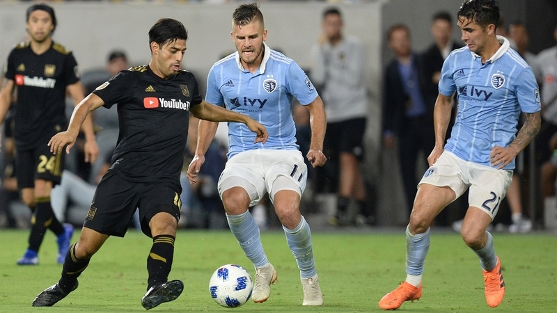 Карлос Вела против игроков «Спортинг Канзас-Сити»